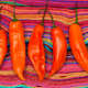 Aji amarillo peppers on a multicolored woven rug